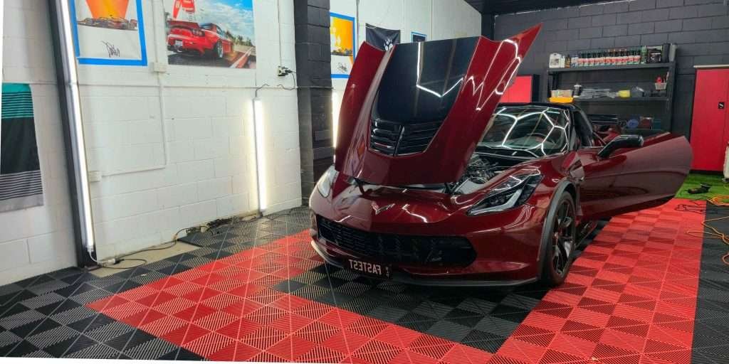 Red Corvette with the bonnet open in the workshop