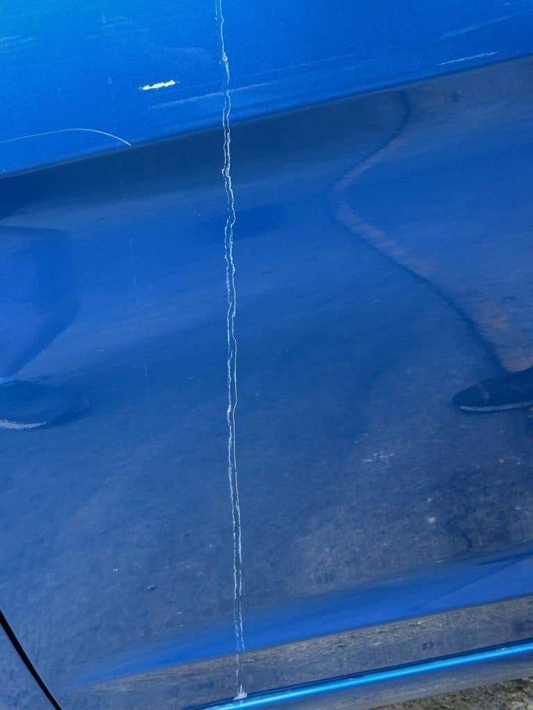 Scratch in blue paint before paint correction