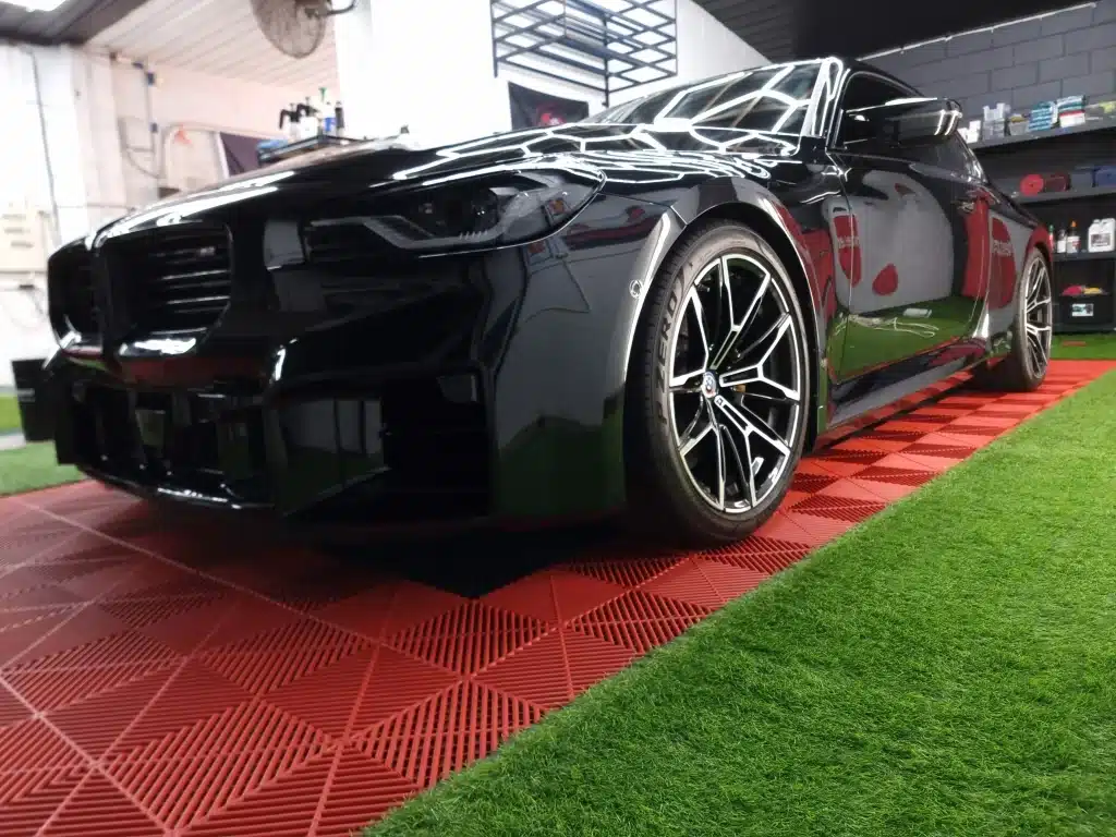 Black performance car on the workshop turf after ceramic coating