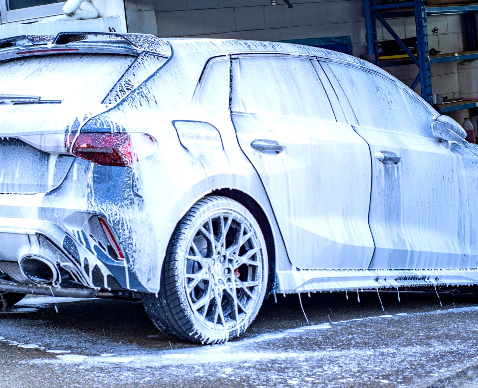 Car fully coated in thick snow foam during the pre-wash decontamination stage