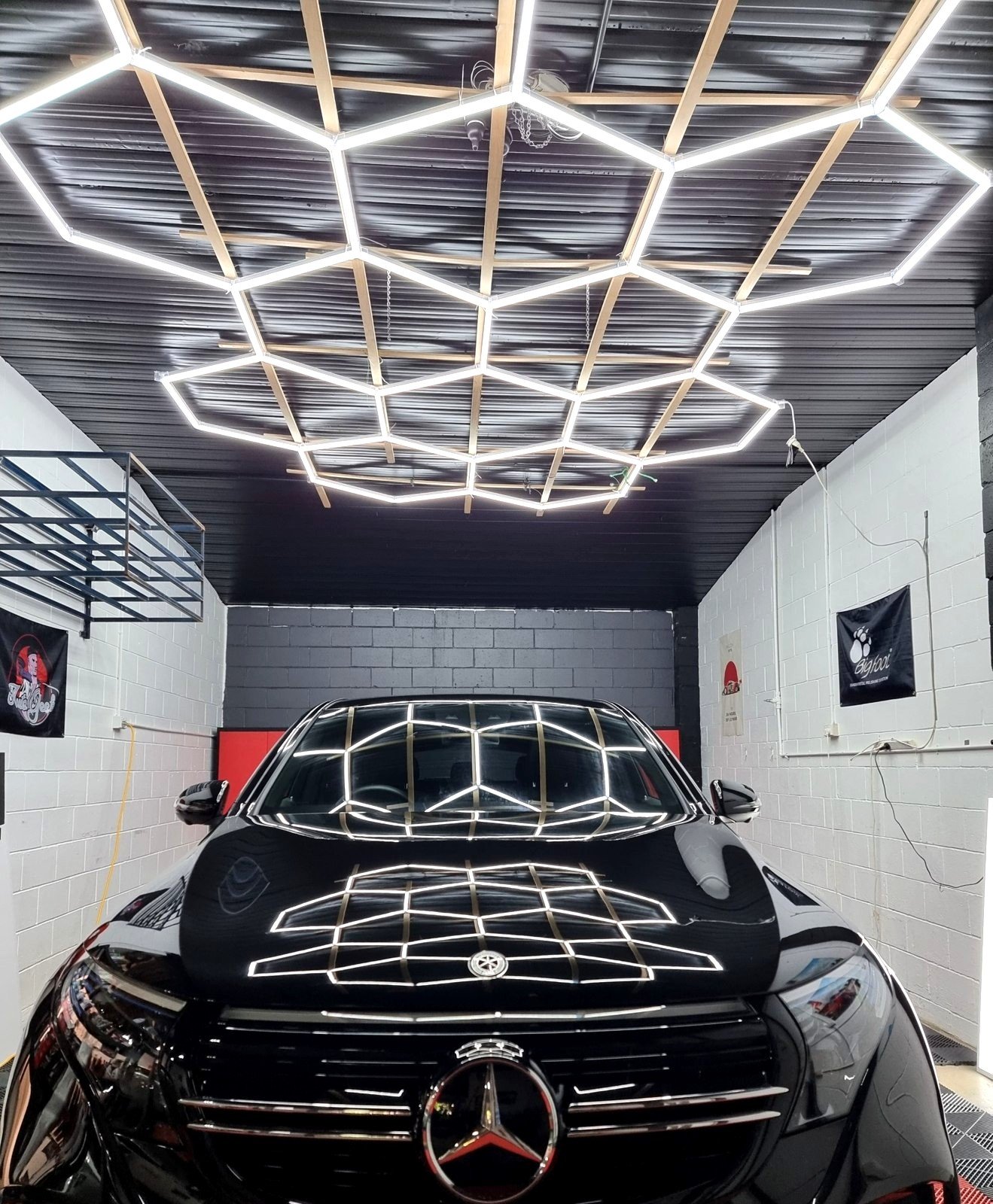 Black Mercedes-Benz bonnet and windscreen reflecting the full hexagon light rig after a ceramic coating finish