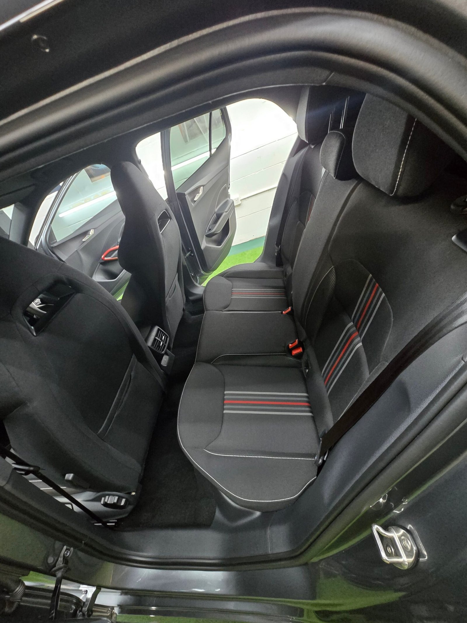 Freshly detailed rear seats with red-striped fabric trim after interior restoration