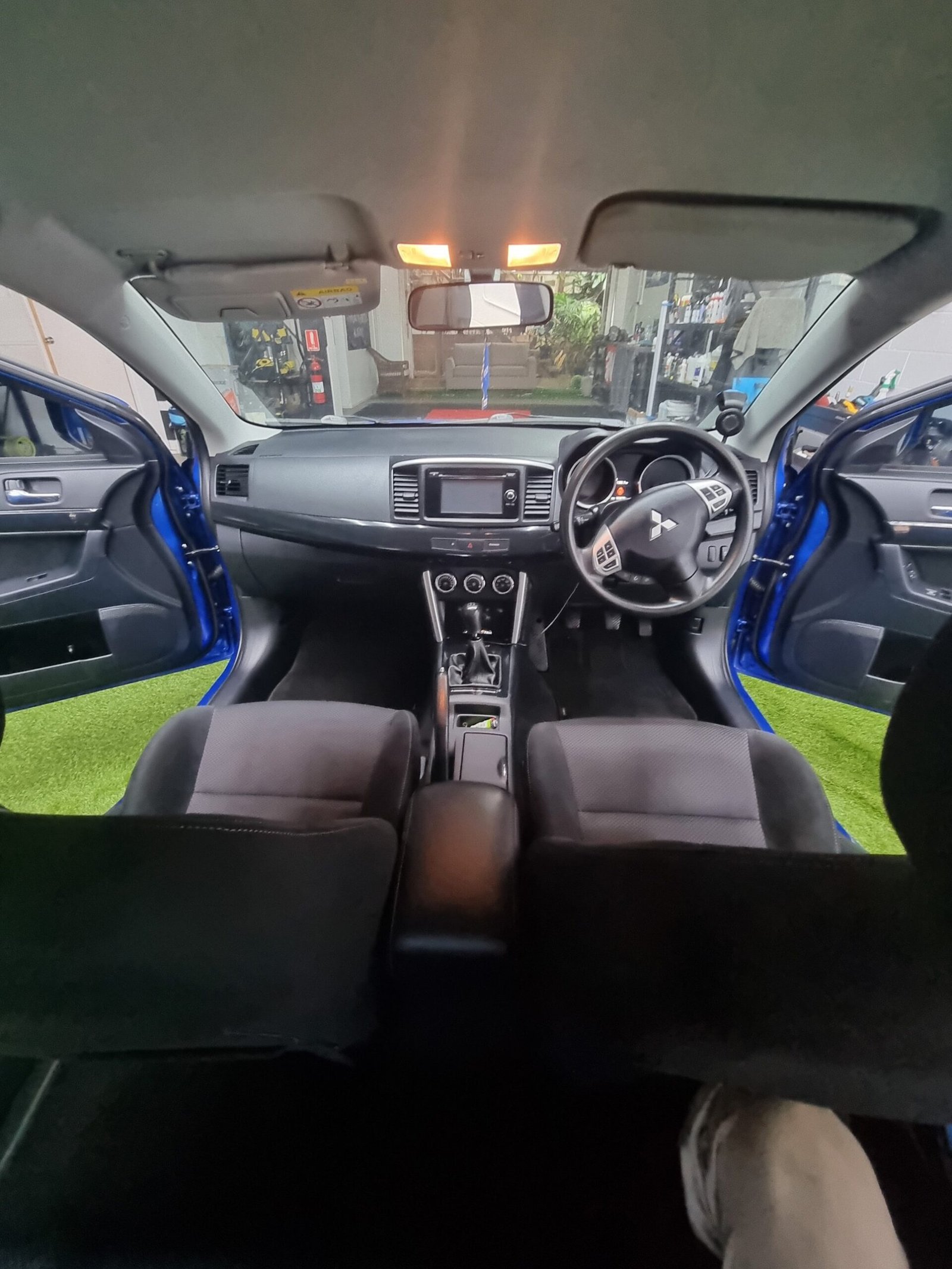 Dark Mitsubishi Lancer Evolution interior after a full detail, dashboard and steering wheel clearly visible